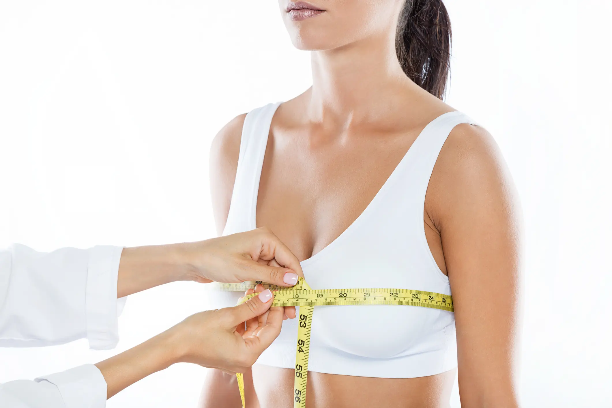 Doctor with measure tape measuring the size of the patient's breast. Breast Reduction in Middletown, NJ